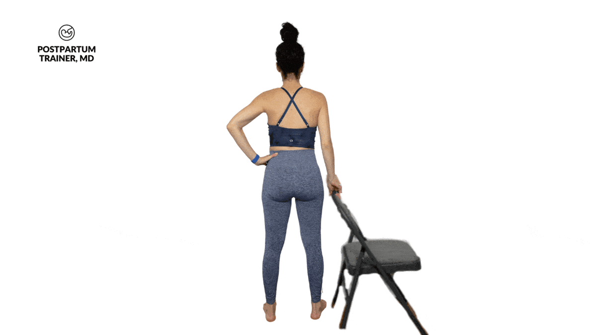 pregnant woman performing calf raises and holding onto a chair for support