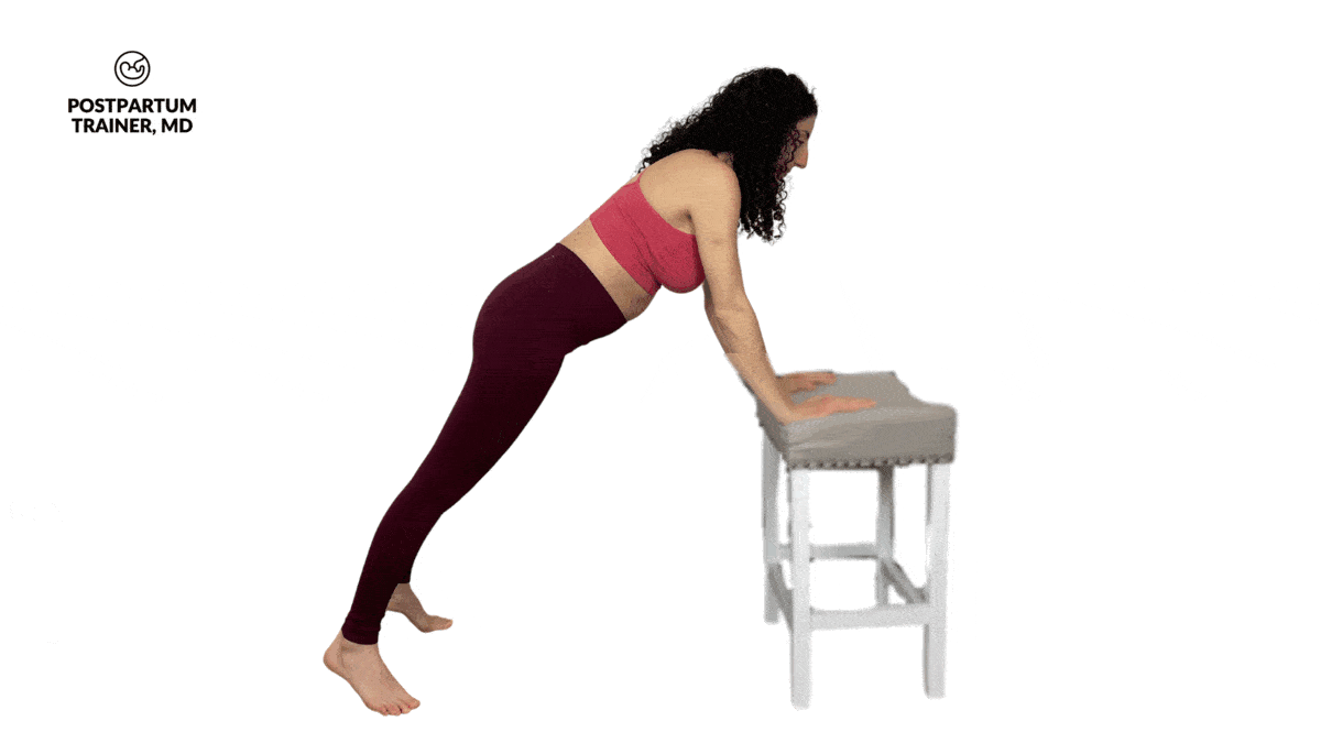 pregnant woman performing incline push up with a reach on a chair