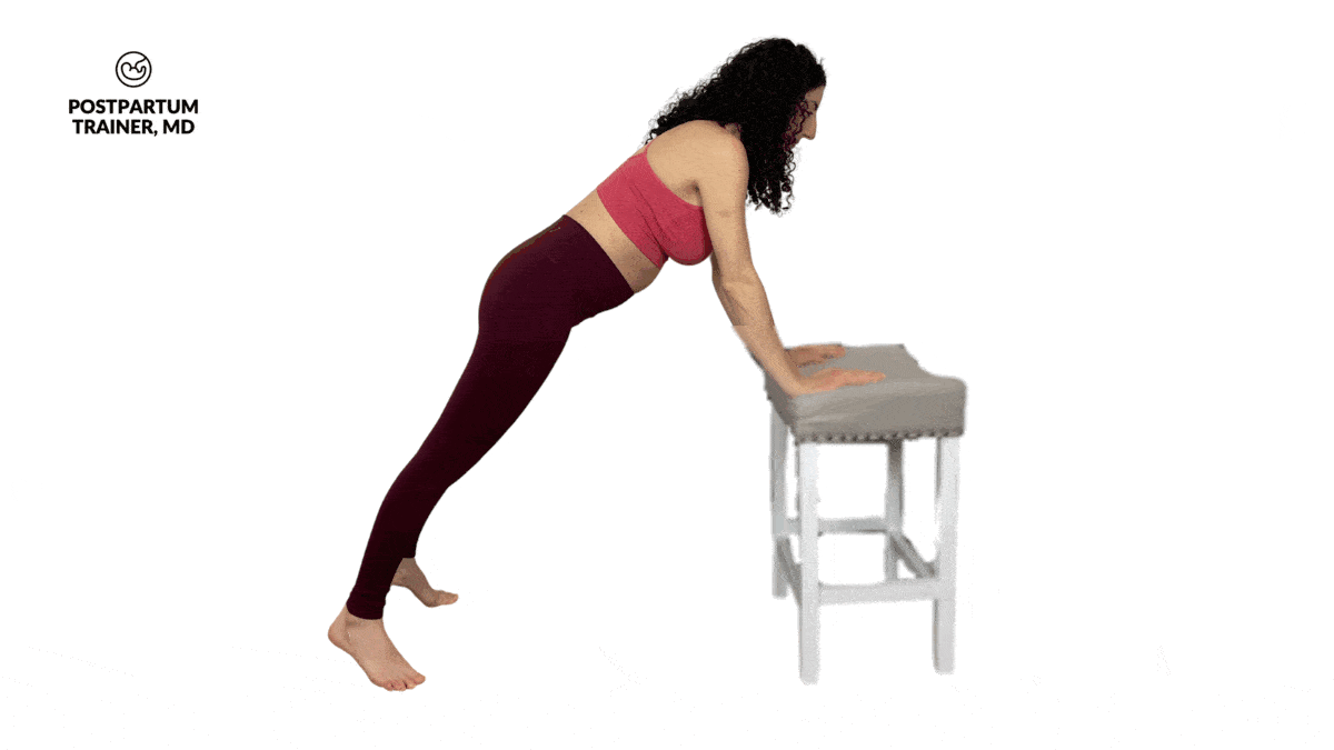 pregnant woman performing incline push up with a row on a chair