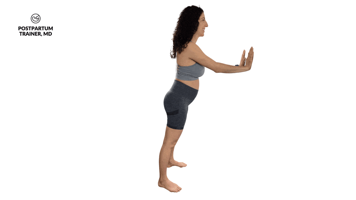 pregnant woman performing sphinx push ups against a wall