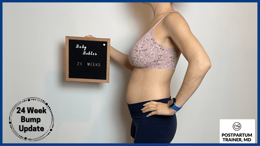 brittany holding a 24 week pregnant sign showing her pregnant belly bump