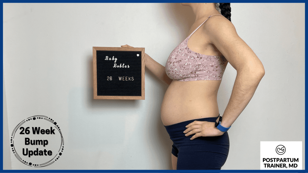 brittany holding up sign at 26 weeks pregnant from side